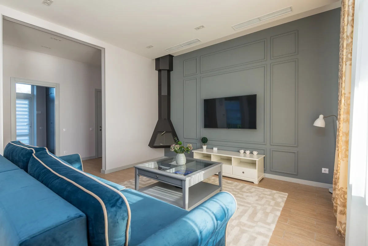 Bright living room with a blue sectional and a coffee table.